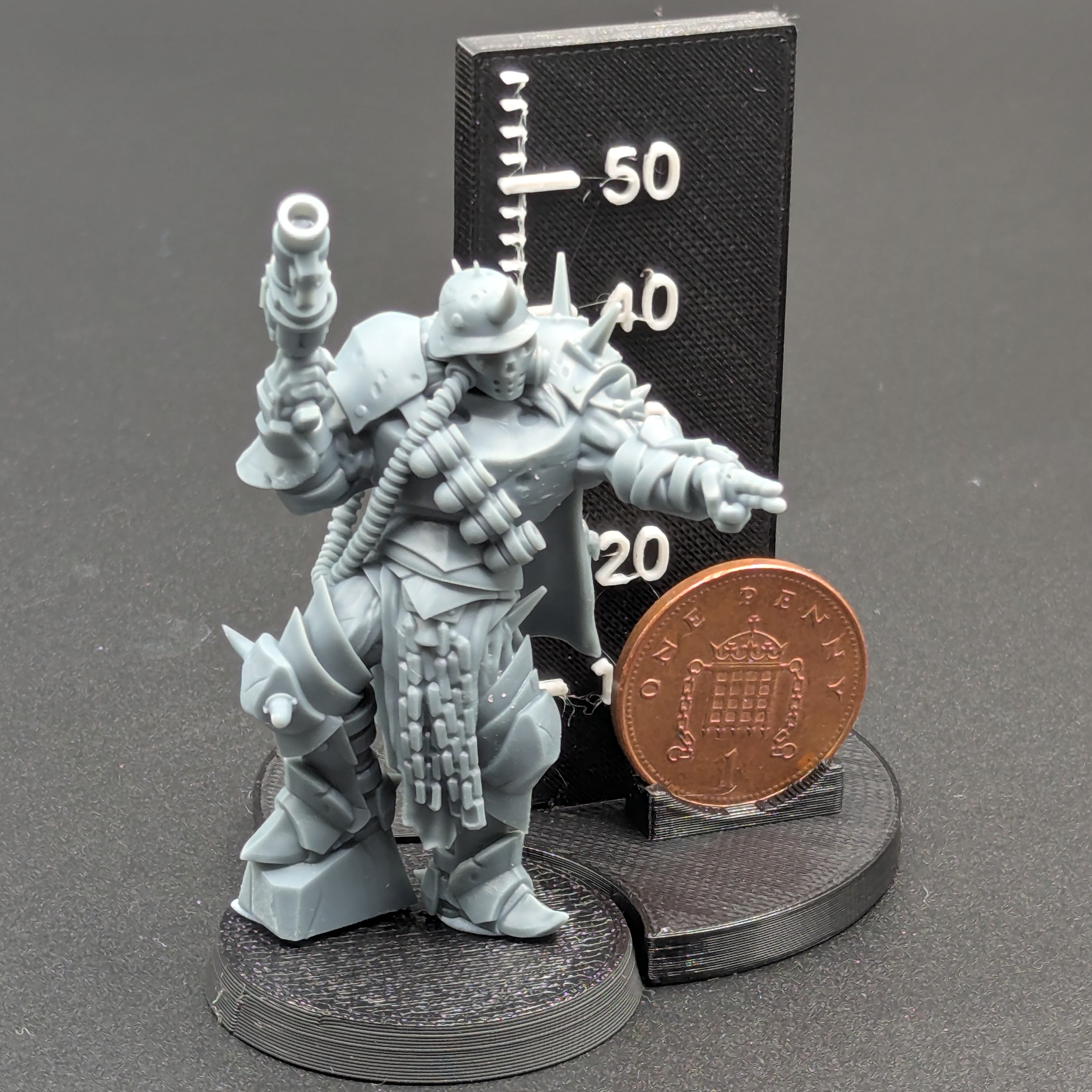 Hellbound Apostasy Anointed with Grenade Launcher. Printed in grey resin, next to a scale showing height with a UK penny as a reference.