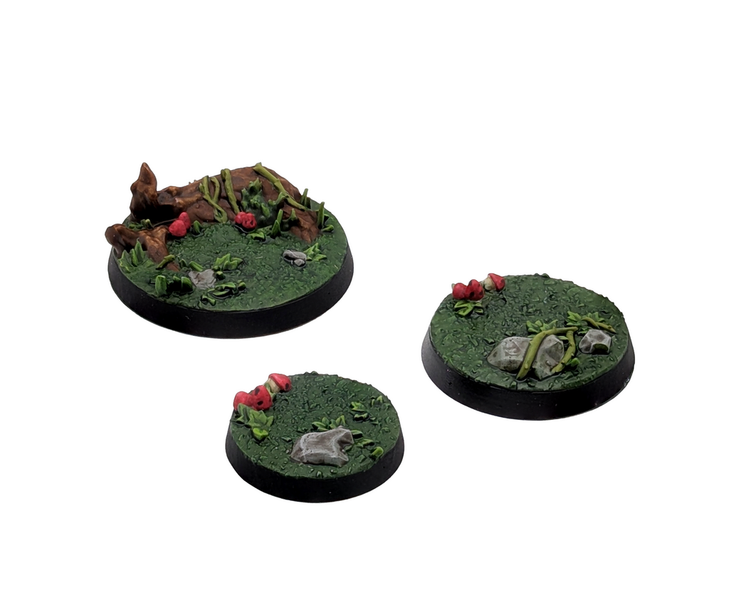 Three Txarli Factory Forest Scenic Bases 40mm, 32mm and 25mm. Shown painted on a white background.