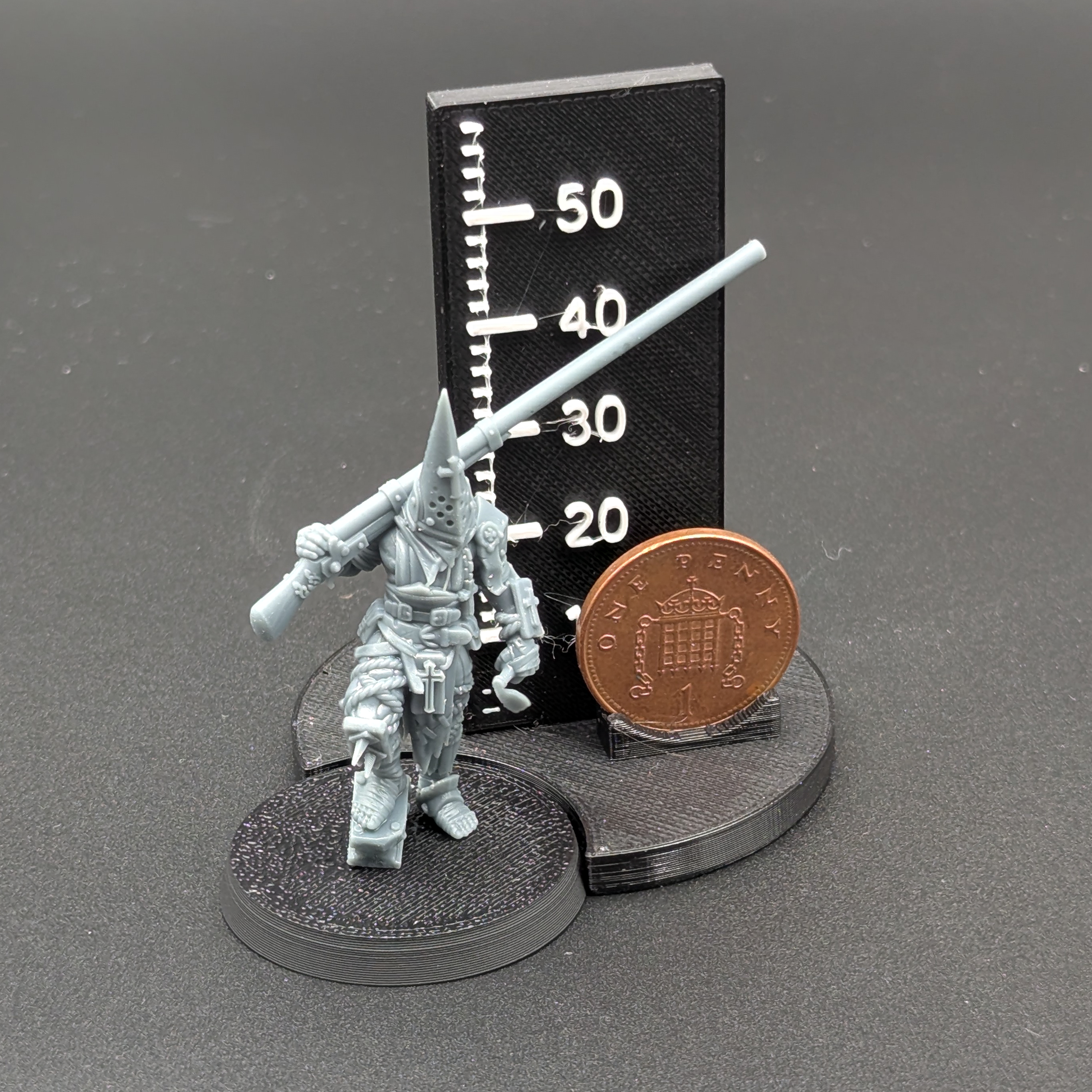 An Ashen Armies Puntgun Pilgrim from the Bleeding Procession Warband. Standing next to a penny for scale.