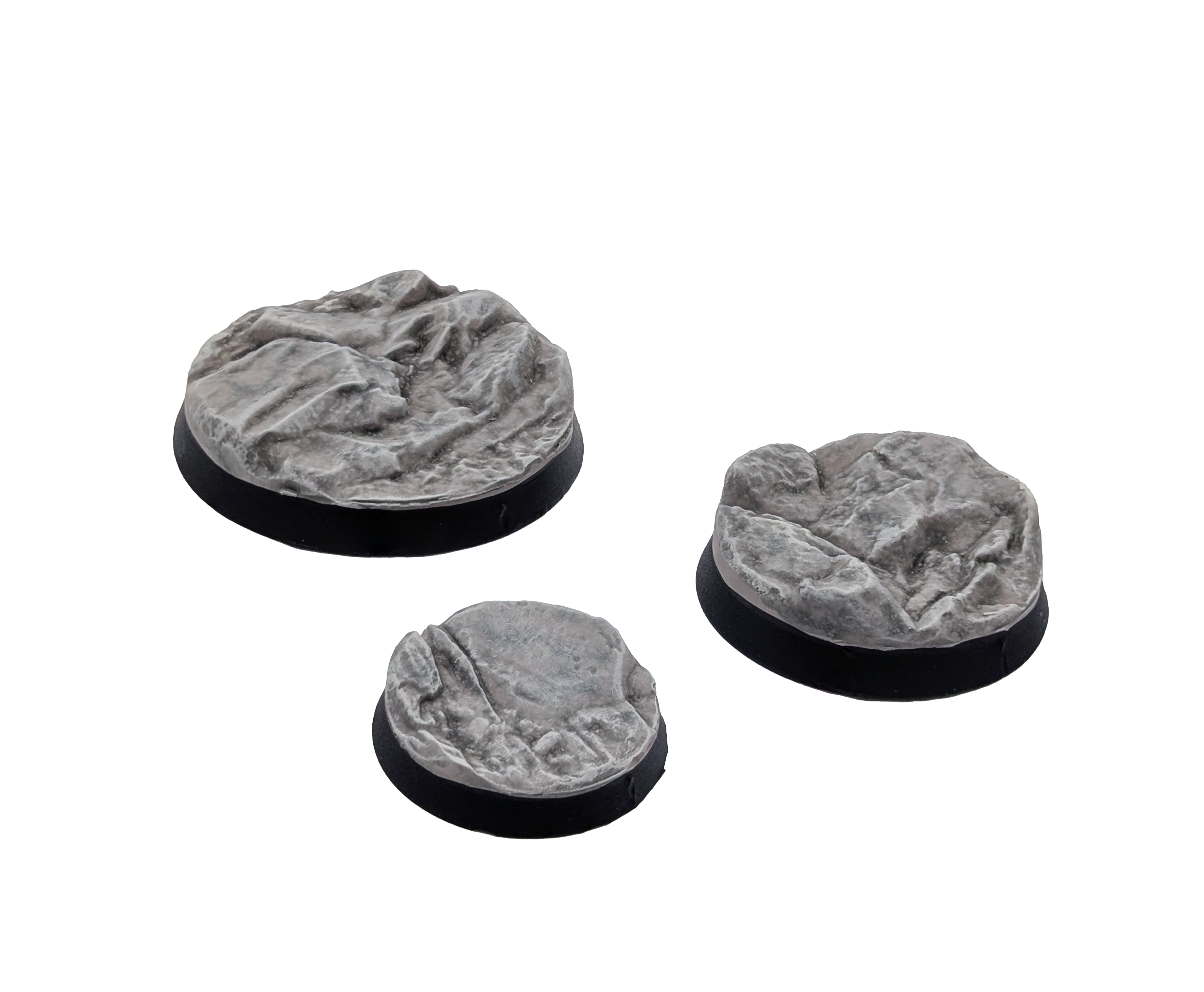 Three painted bases from the Txarli Rocky set on a plain white background. 25mm, 32mm and 40mm