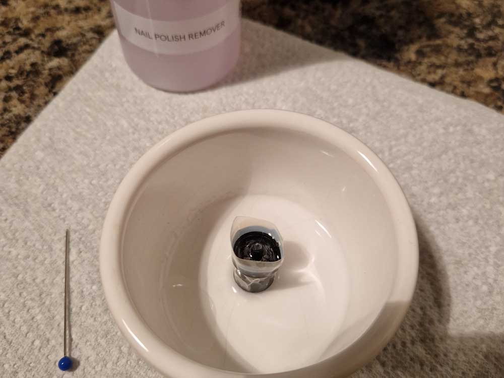 Close up photograph of one previously very dirty spray can cap that has been cleaned. As per the spray can caps guide.