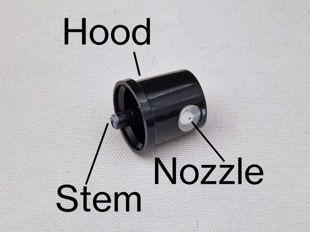 Annotated photo showing component parts of a spray can cap.