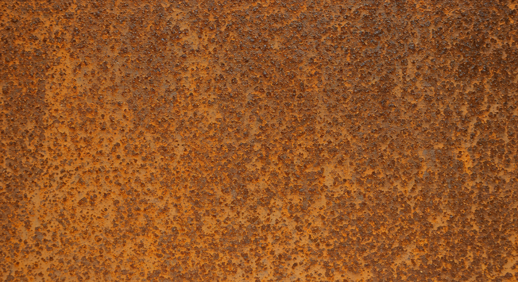 A rectangle of sheet steel showing heavy level of rusting. I am calling it level five of six. This sheet is heavily and more deeply rusted all over. Small areas of medium rust visible.